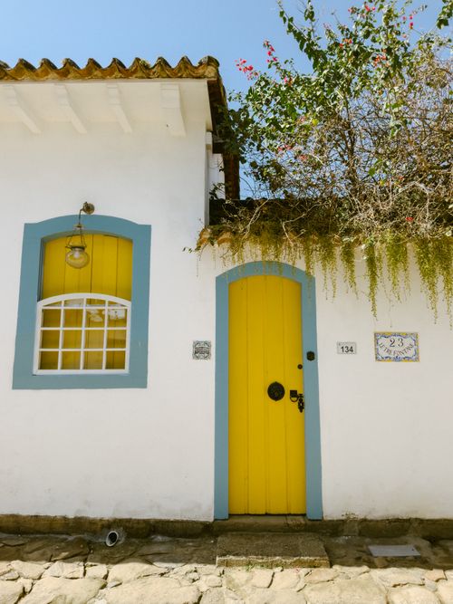 Free Vibrant yellow door with blue frame in historic Paraty, Brazil. Colonial architecture. Stock Photo