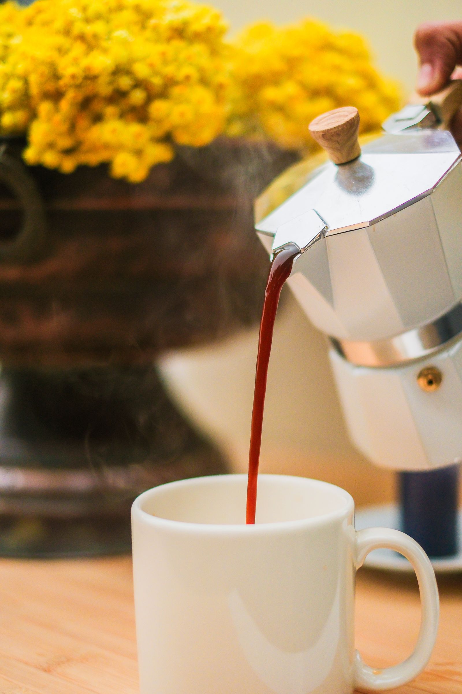 Dark, concentrated coffee being poured from a stovetop moka pot