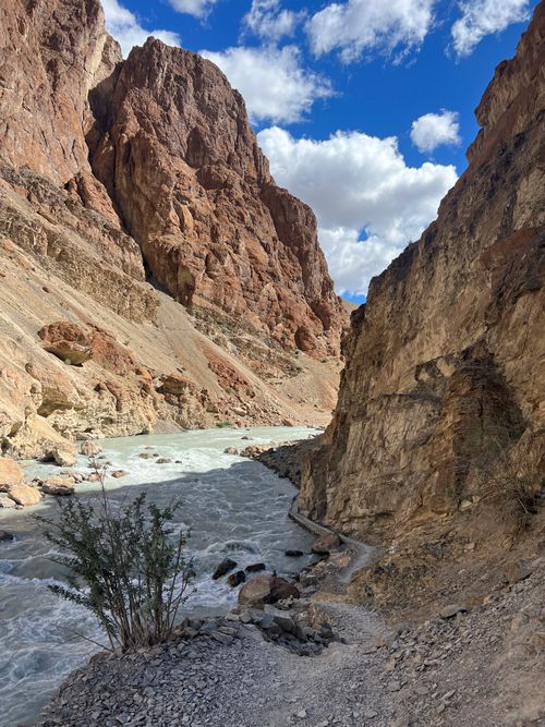 Free Capture of a pristine river cutting through a steep, rugged canyon under a bright blue sky. Stock Photo