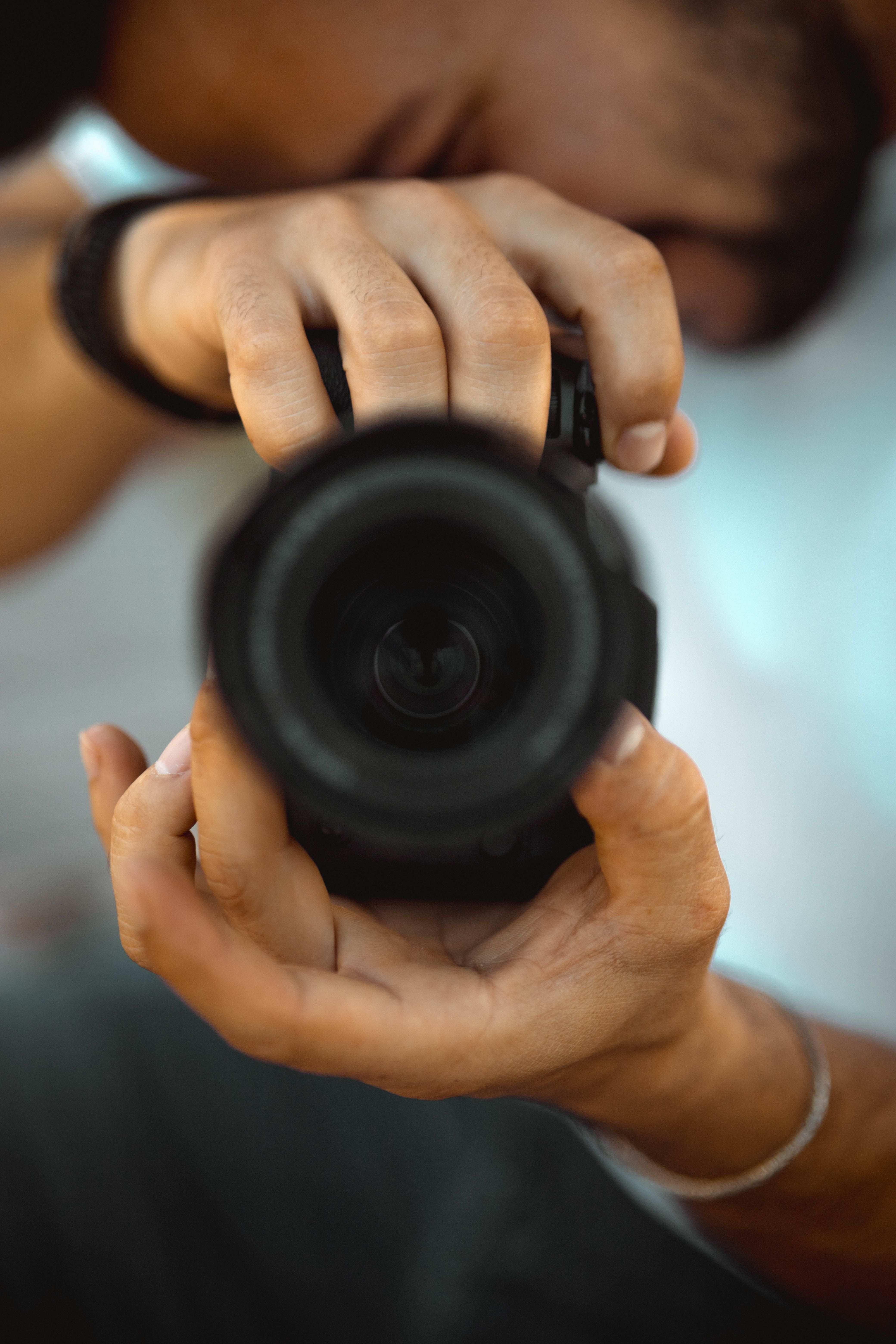 A detailed focus on a person adjusting a camera lens, showcasing photography precision.
