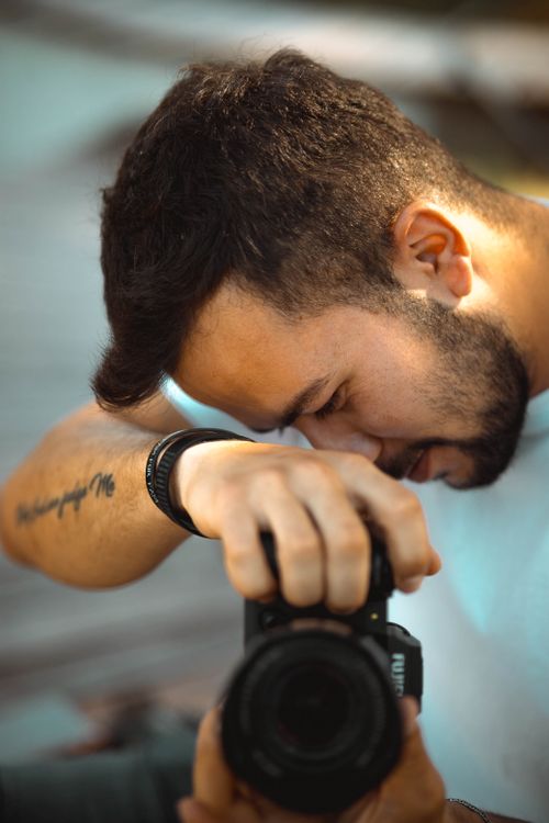 Free Focused photographer taking a shot outdoors, showcasing creative passion. Stock Photo