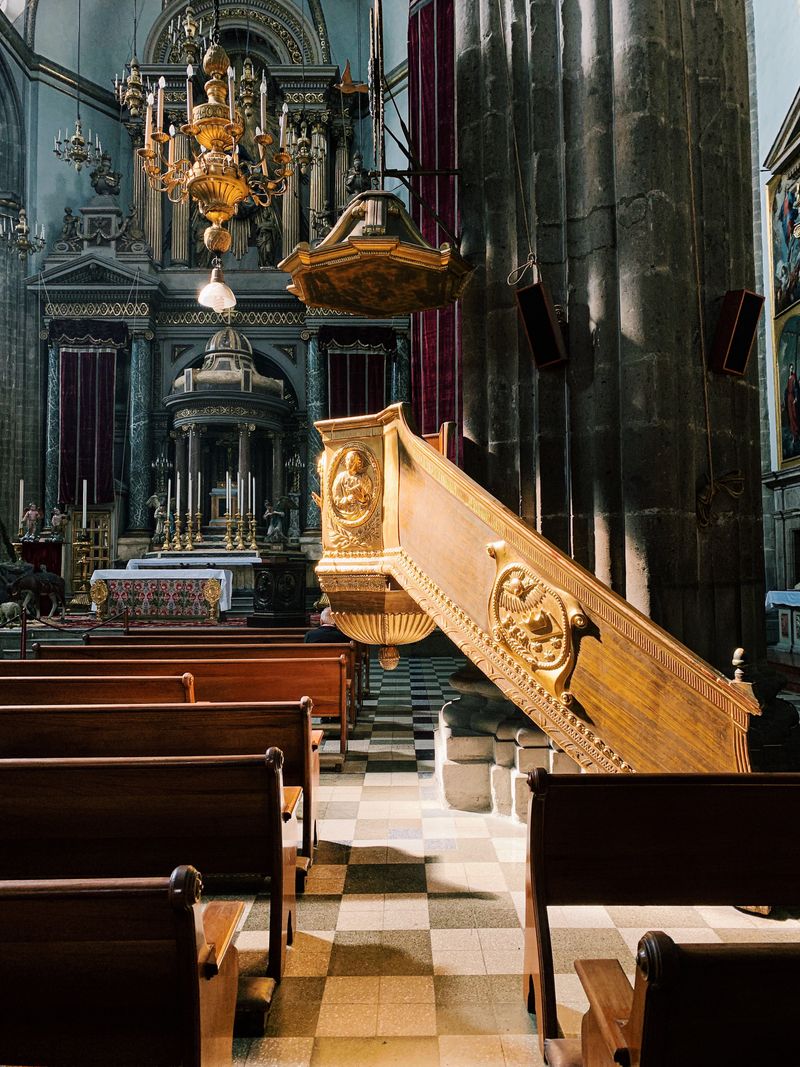 Ornamented historic church interior with pews and altar