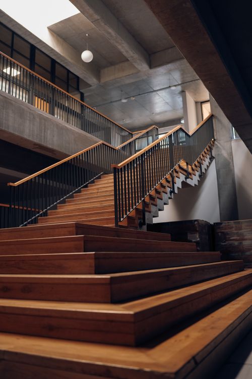 Free Elegant wooden staircase with sleek handrails in a modern interior setting. Stock Photo