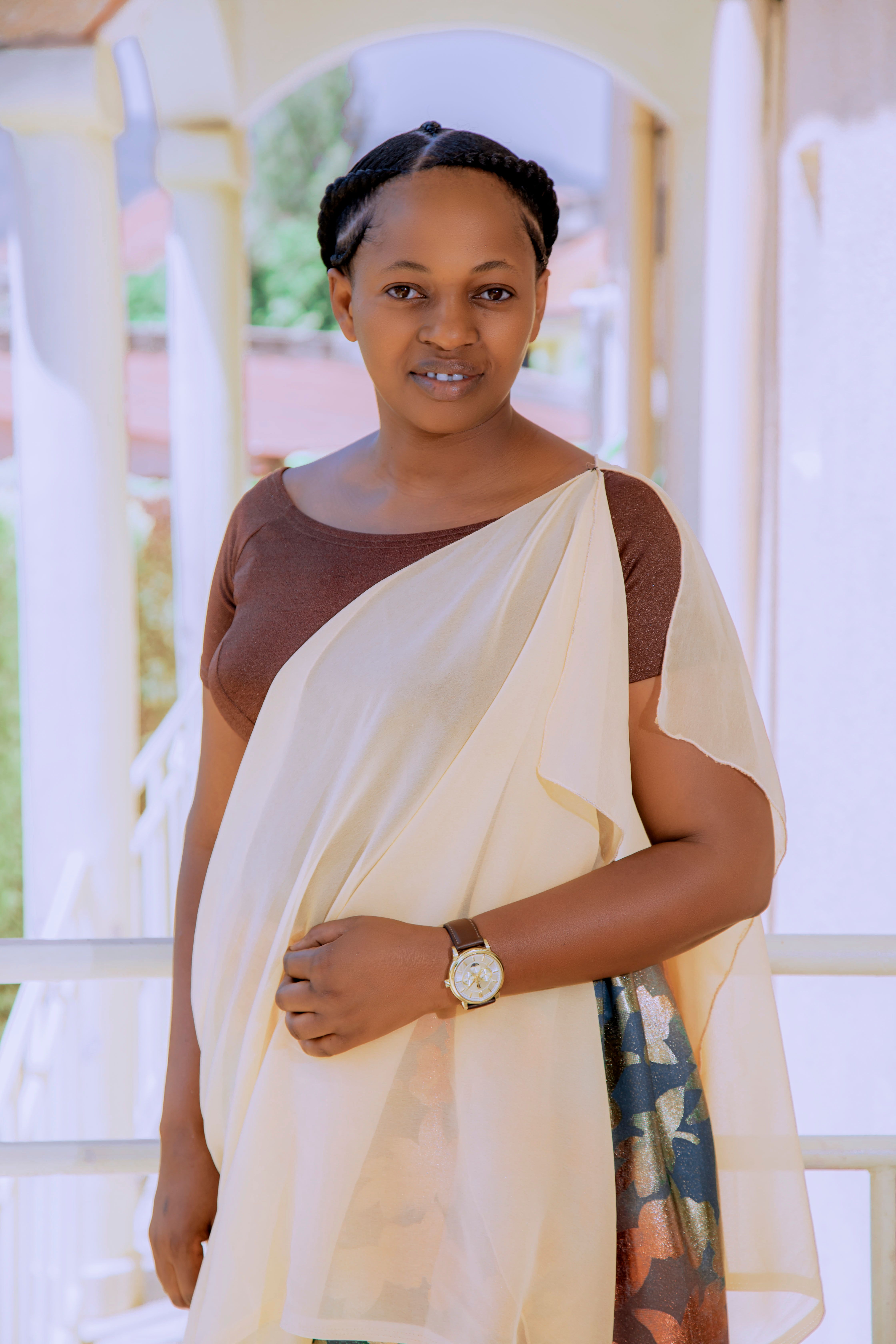 A beautiful portrait of a smiling woman in traditional attire standing indoors, captured in soft lighting.
