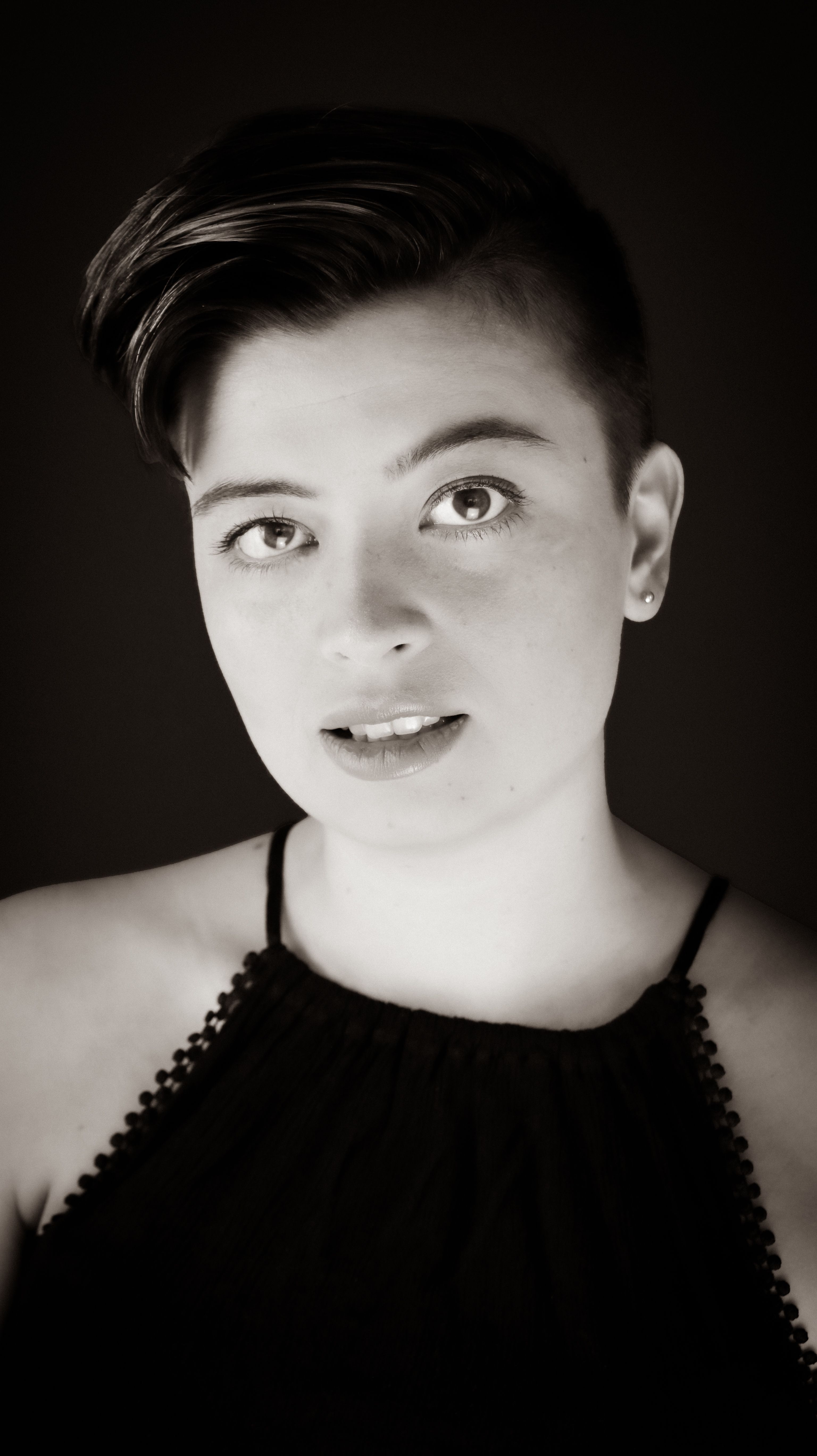 Captivating black and white portrait of a young woman with a short hairstyle.