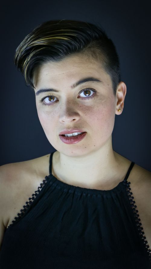 Free Stylish portrait of a woman with short hair and a confident expression against a black background. Stock Photo