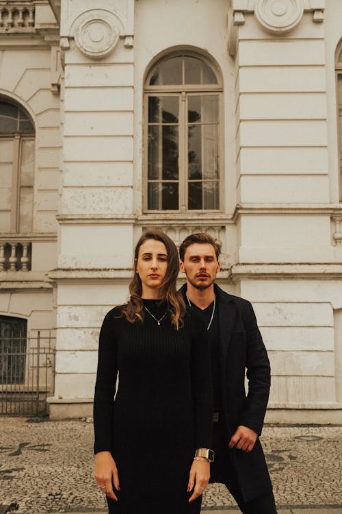 Elegant Man and Woman Standing in front of a Traditional Building 