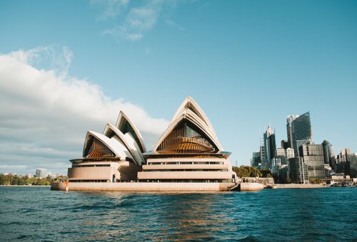 Free Stunning view of the Sydney Opera House against the modern city skyline on a clear day. Stock Photo