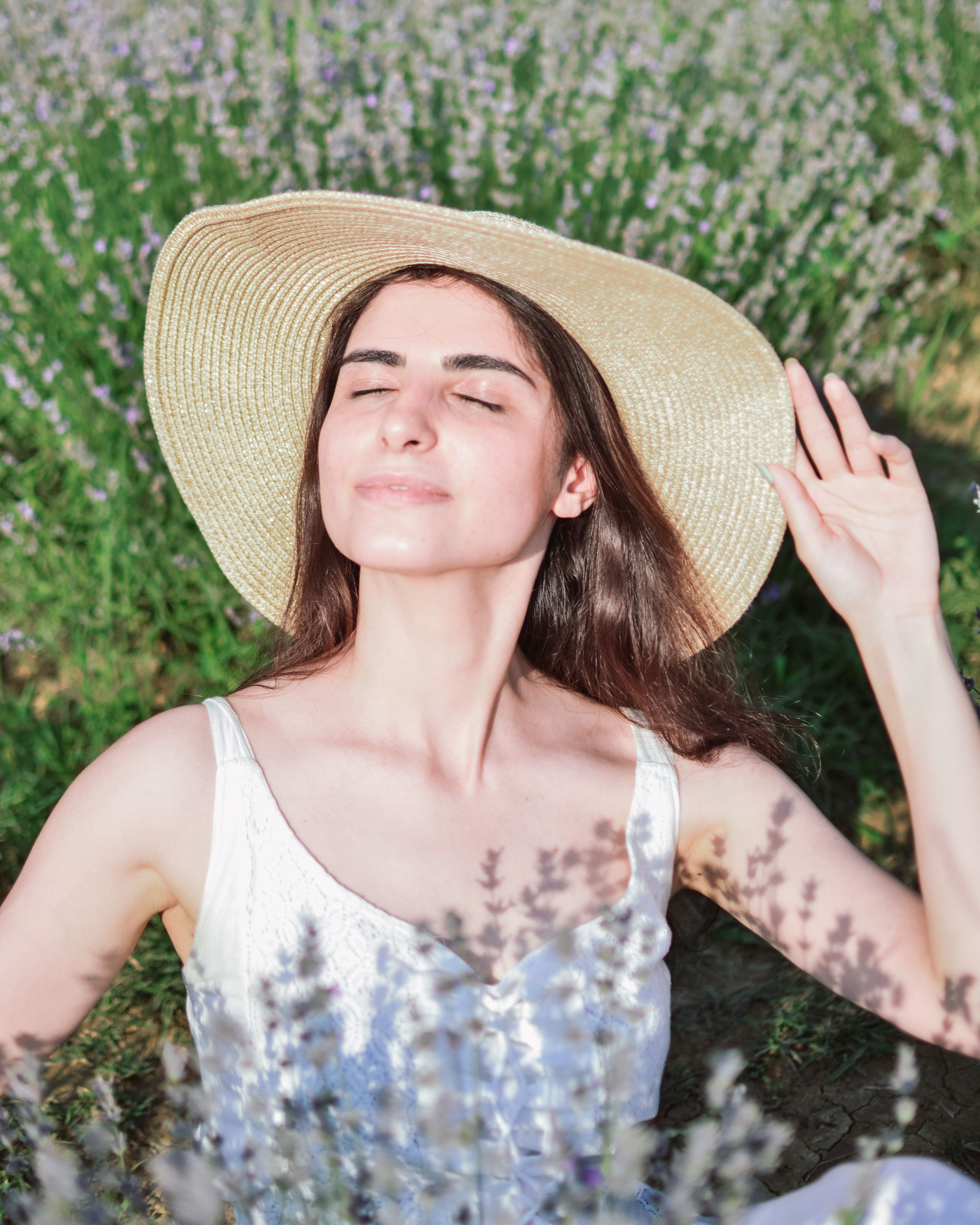 Woman in Hat and with Eyes Closed on Meadow · Free Stock Photo