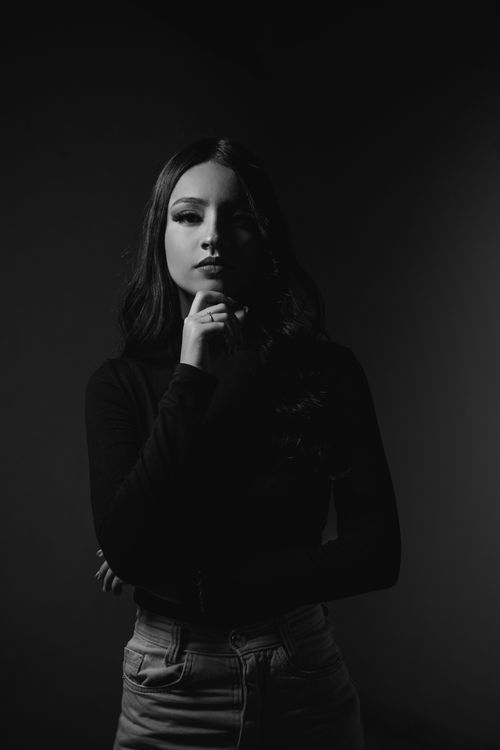 Free Striking black and white portrait of a young woman in thoughtful pose, studio setting. Stock Photo