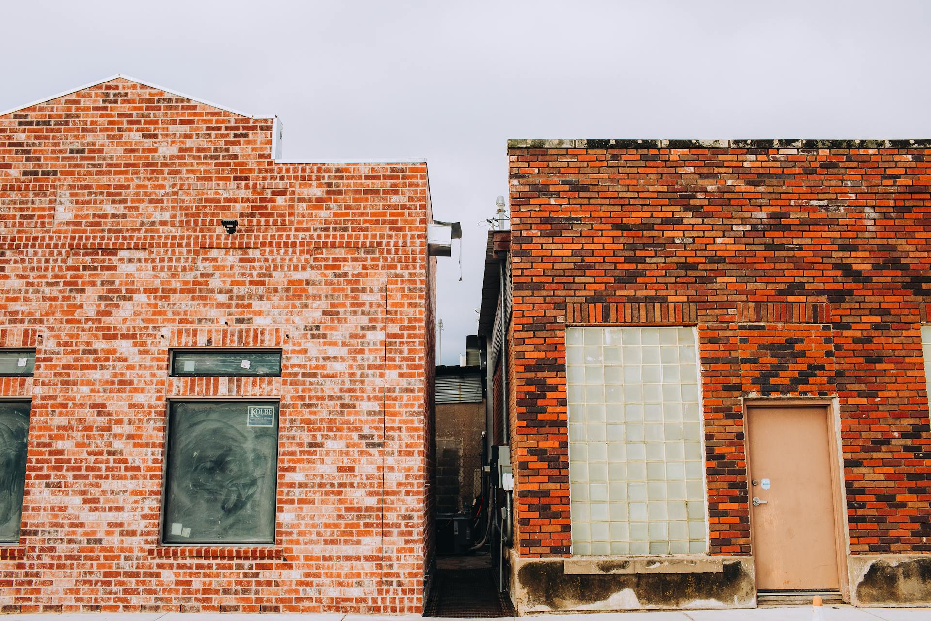 Two brick building facades with unique patterns in a vintage urban setting.