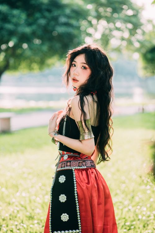 Free A beautiful woman in traditional clothing posing elegantly in a sunlit park. Stock Photo