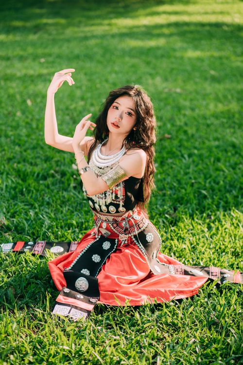 Free Woman in traditional dress posing gracefully on green grass. Fashion photography. Stock Photo