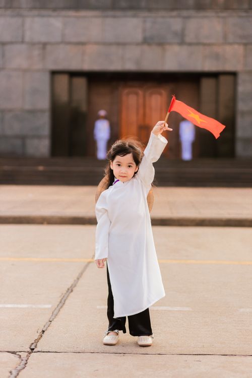 Free Child holding a Vietnamese flag in traditional attire, outdoors. Stock Photo