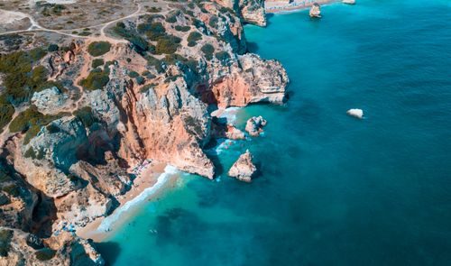 Free A breathtaking aerial shot of rocky cliffs and turquoise ocean waters. Stock Photo