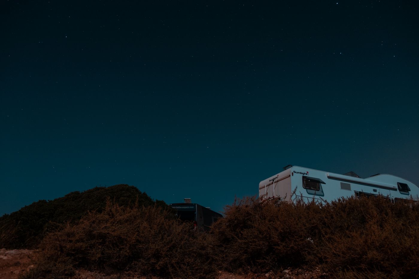 A trailer parked under a starry sky, photo by Mo Eid on Pexels