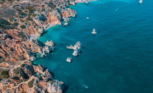 Free High-angle aerial view of a stunning rocky coast with clear blue sea water. Stock Photo