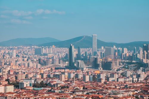Free Spectacular aerial view of a vast urban metropolis with skyscrapers and mountains in the background. Stock Photo