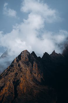 Stunning view of Aladag Mountains with clouds swirling around rocky peaks in Adana, Turkey.