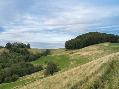 Free Peaceful countryside scene with lush green hills and clear blue sky, ideal for nature enthusiasts. Stock Photo