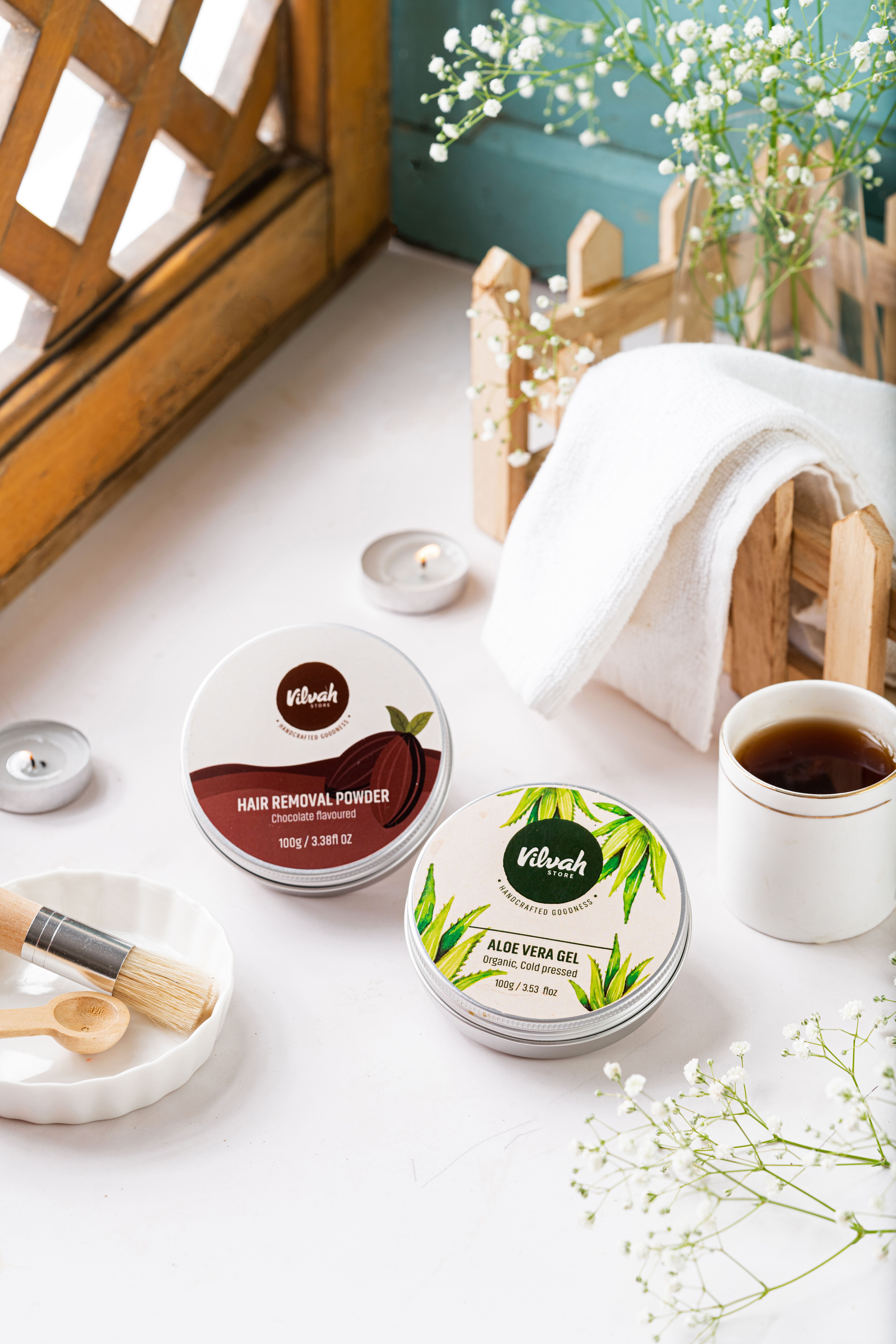 A serene spa setting showcasing natural beauty products with candles, flowers, and a cup of tea.