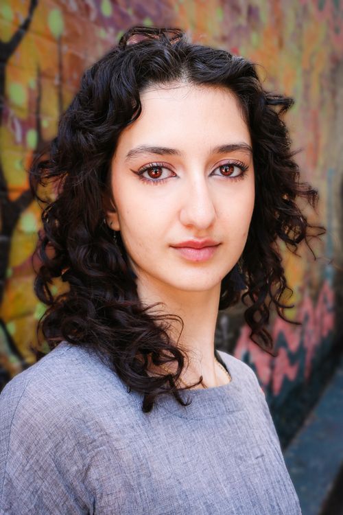 Free Striking portrait of a woman with curly hair against colorful graffiti in Brighton and Hove. Stock Photo