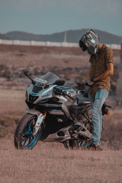 Free Man standing by a motorcycle in a rural area of Salem, Tamil Nadu, India. Stock Photo
