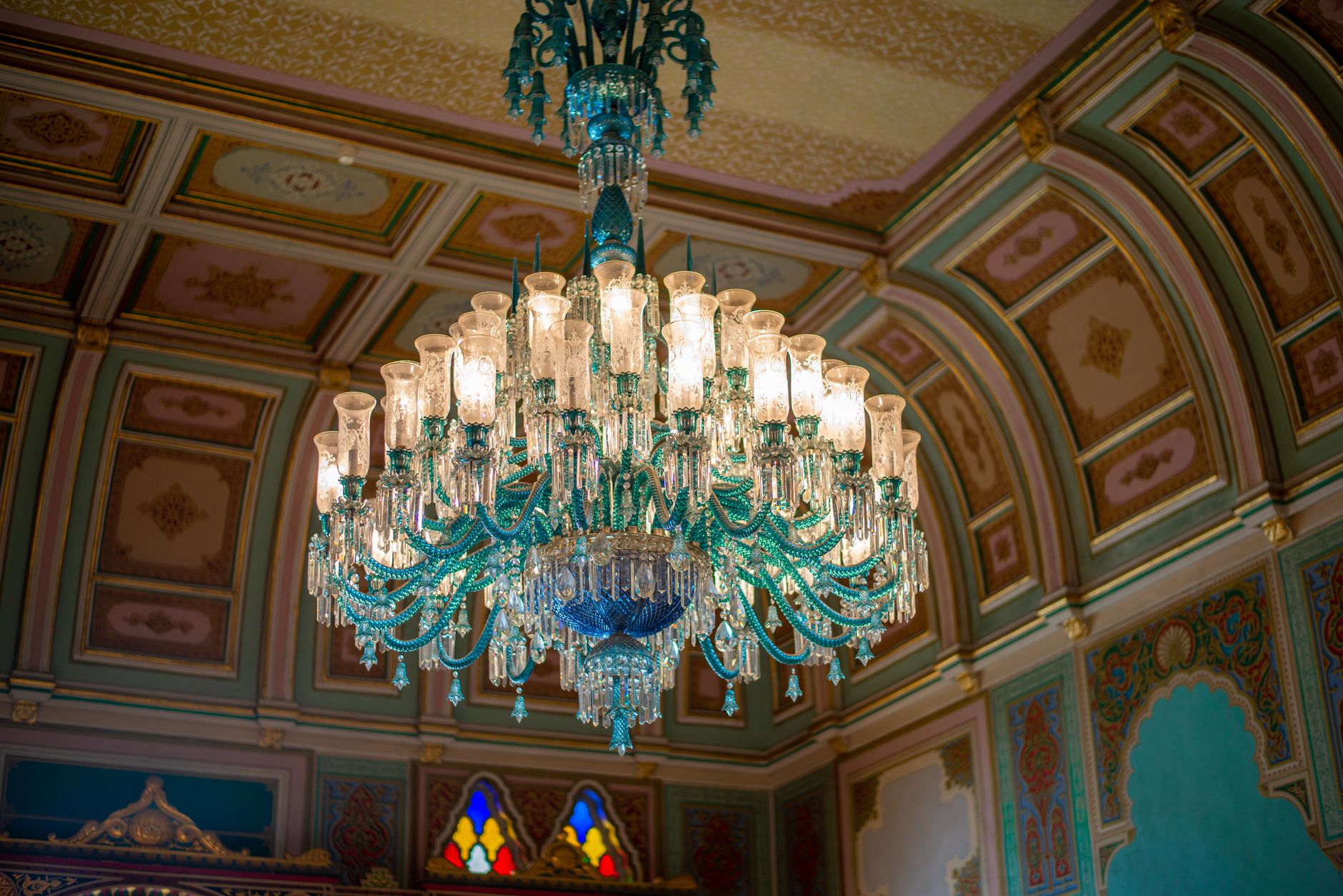 Luxurious chandelier with intricate glasswork in a lavish Istanbul palace setting.