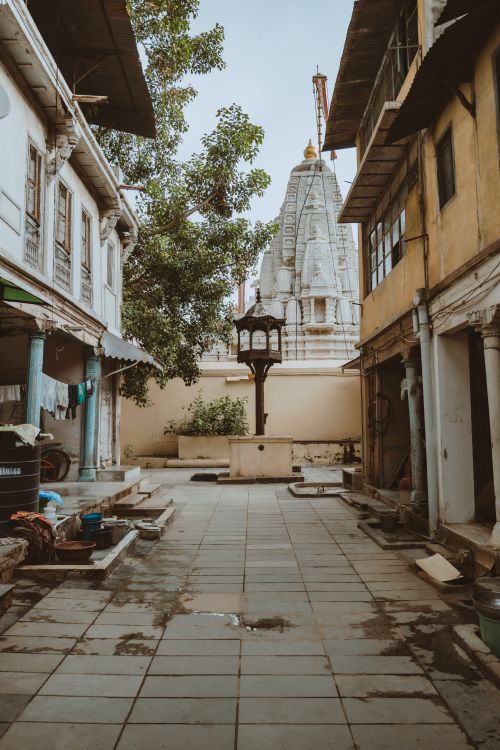 Free A narrow urban alley with traditional buildings leads to a distant temple in a town setting. Stock Photo