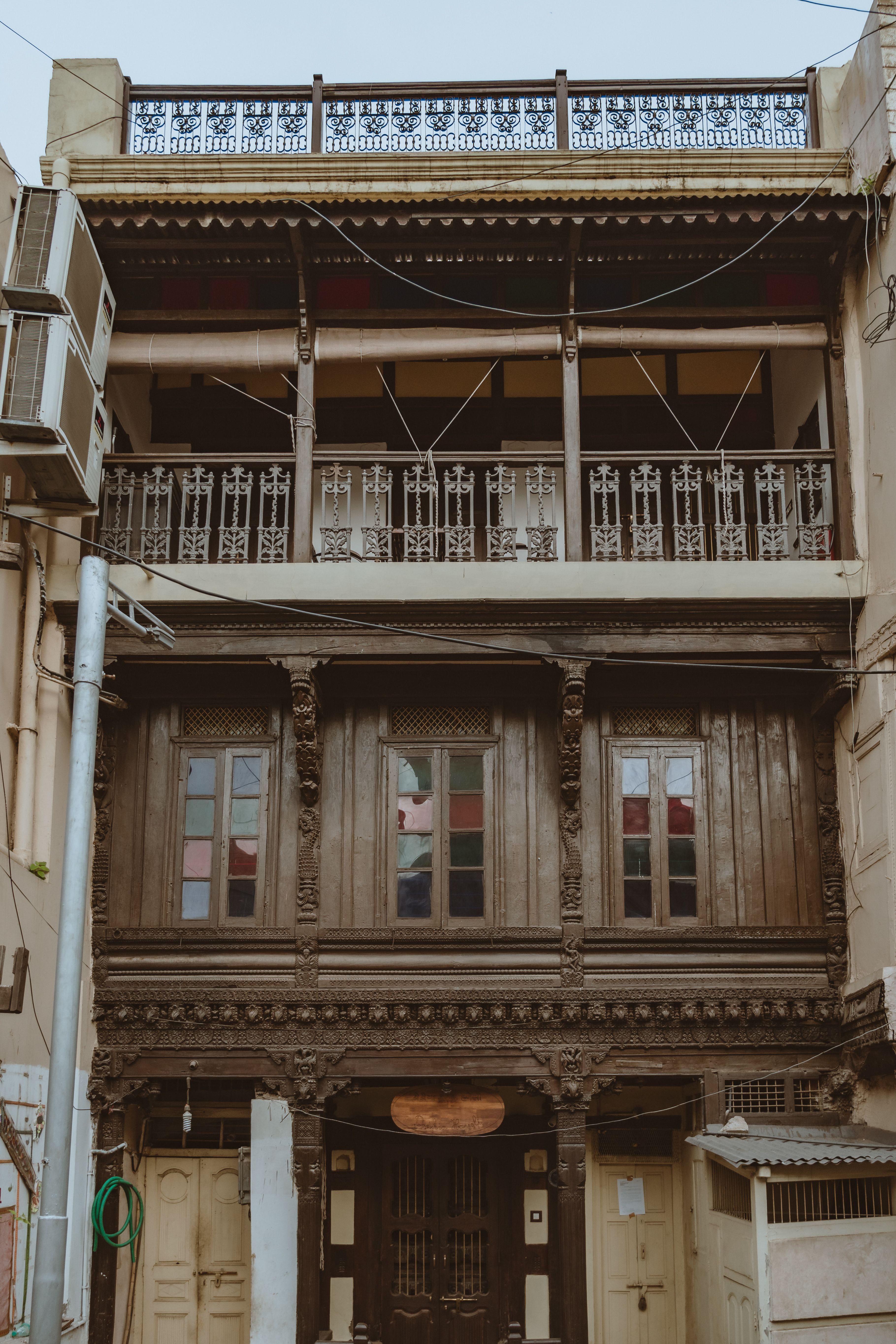 A vintage residential building with intricate wooden balconies in an urban setting.