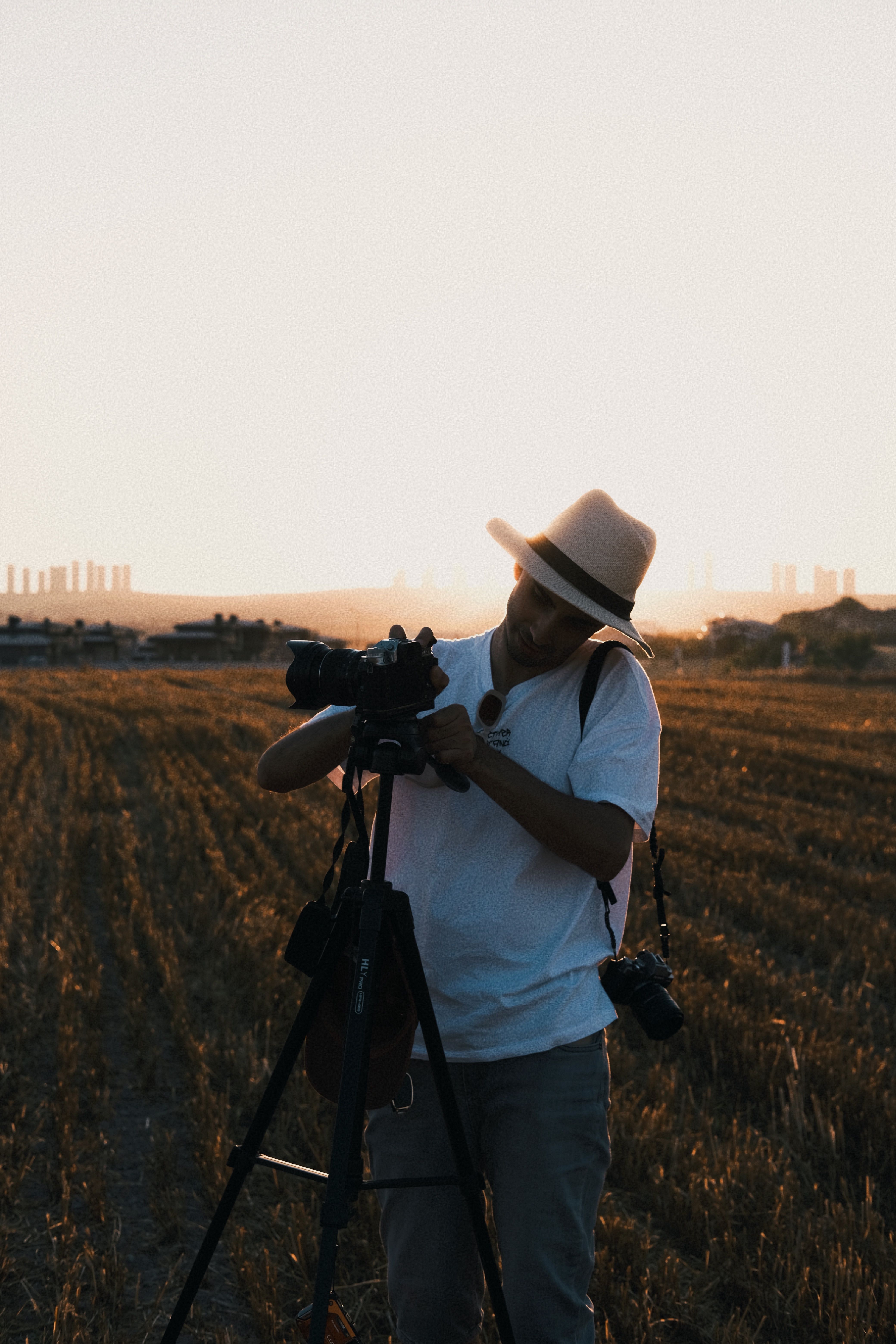 Photographer with camera on tripod capturing a golden hour landscape