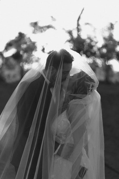 Black and White Shot of a Newlywed Couple Kissing 
