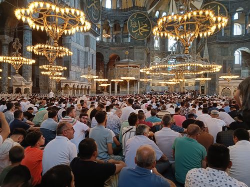 Free Large gathering inside Hagia Sophia Mosque for prayer, showcasing chandeliers and Islamic architecture. Stock Photo