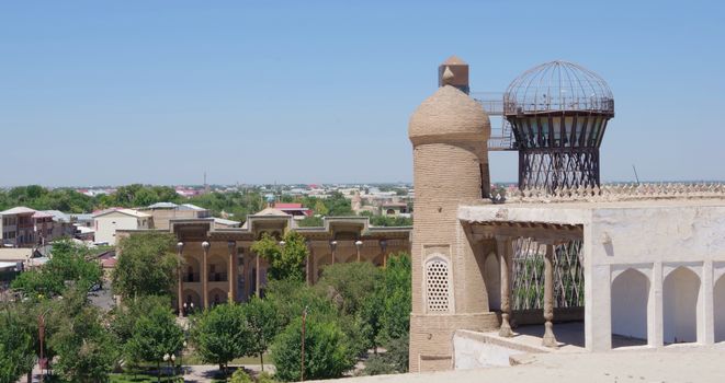 Scenic view of ancient buildings and lush greenery in Boukhara, Uzbekistan.