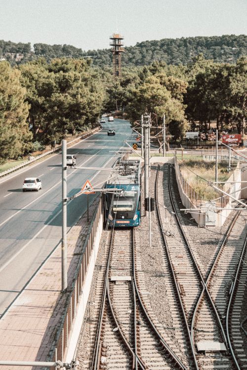 Free Aerial view of a tram and vehicles on a tree-lined street during summer. Stock Photo