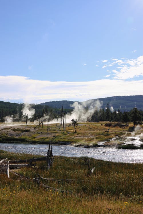Mountain Valley Landscape with a River and Plumes of Geyser Steam, Yellowstone, USA