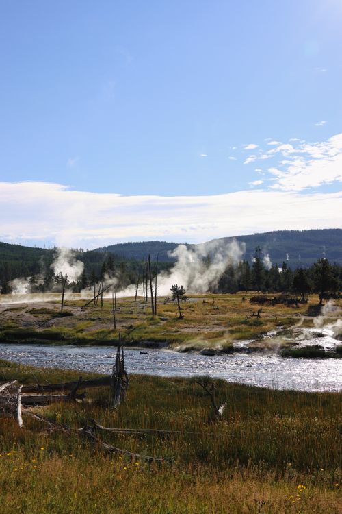 Free Beautiful landscape of geysers and river in Yellowstone National Park, USA, under blue skies. Stock Photo