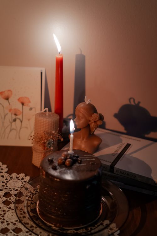 Free Warm ambient setup featuring candles, a chocolate cake, and floral decor creating a cozy atmosphere. Stock Photo