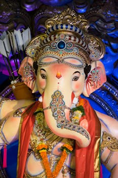 Colorful Ganesh idol adorned with jewels and floral garlands, embodying Indian culture and spirituality.