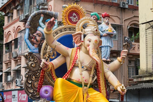 Colorful Ganesh statue amidst a bustling street during the festival in Mumbai, India.
