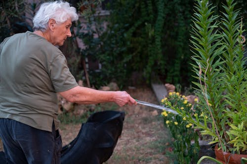 Old woman watering plants 