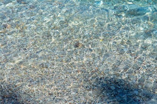 Free Crystal clear shallow waters revealing pebbles, creating a serene and tropical summer scene. Stock Photo