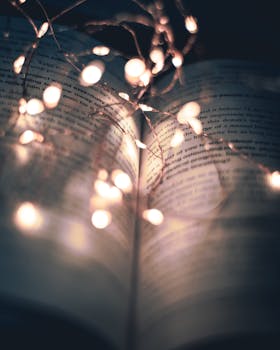 An open book illuminated by delicate string lights, creating a warm and serene ambiance.