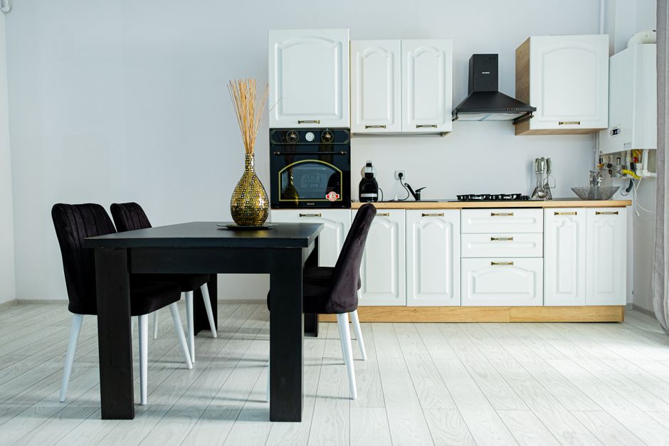 Kleiner Essplatz in moderner Küche mit schmalem Holztisch, Bank an der Wand und hellen Fronten