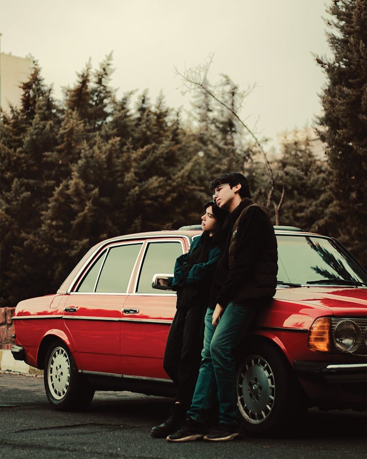 Couple Standing By Vintage Car