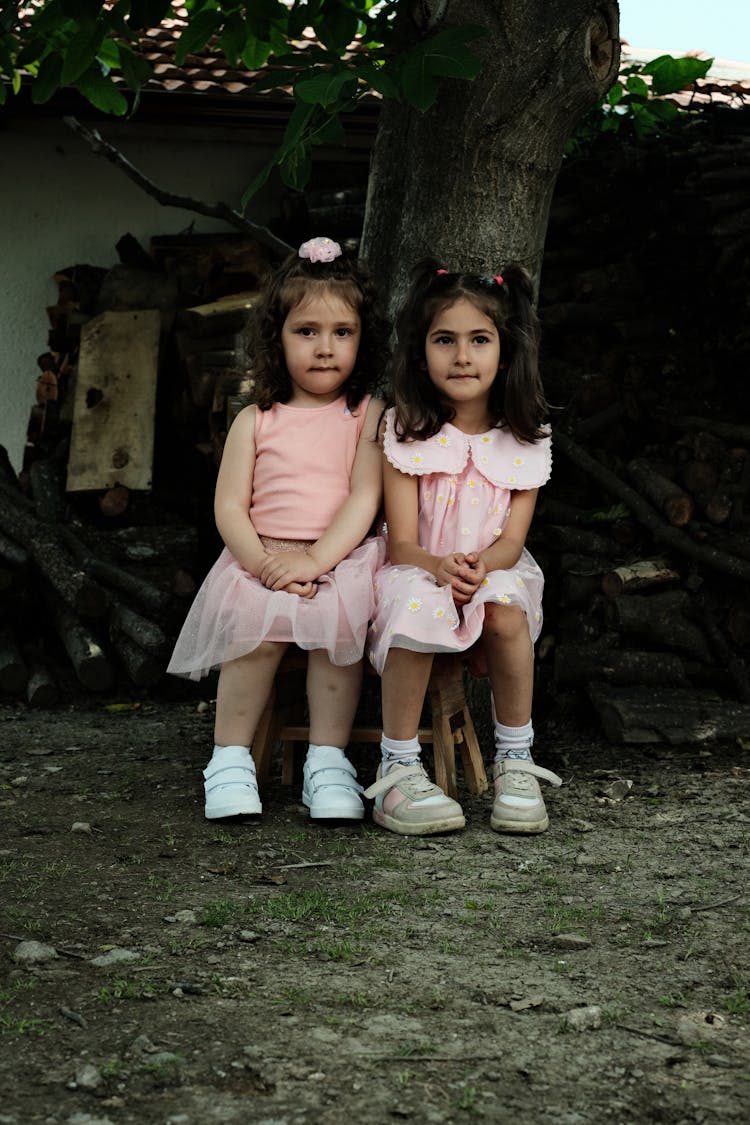 Two Little Girls Sitting Under A Tree