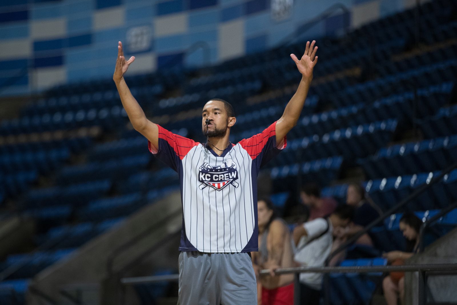 Árbitro apitando e sinalizando durante partida de basquete em ginásio coberto
