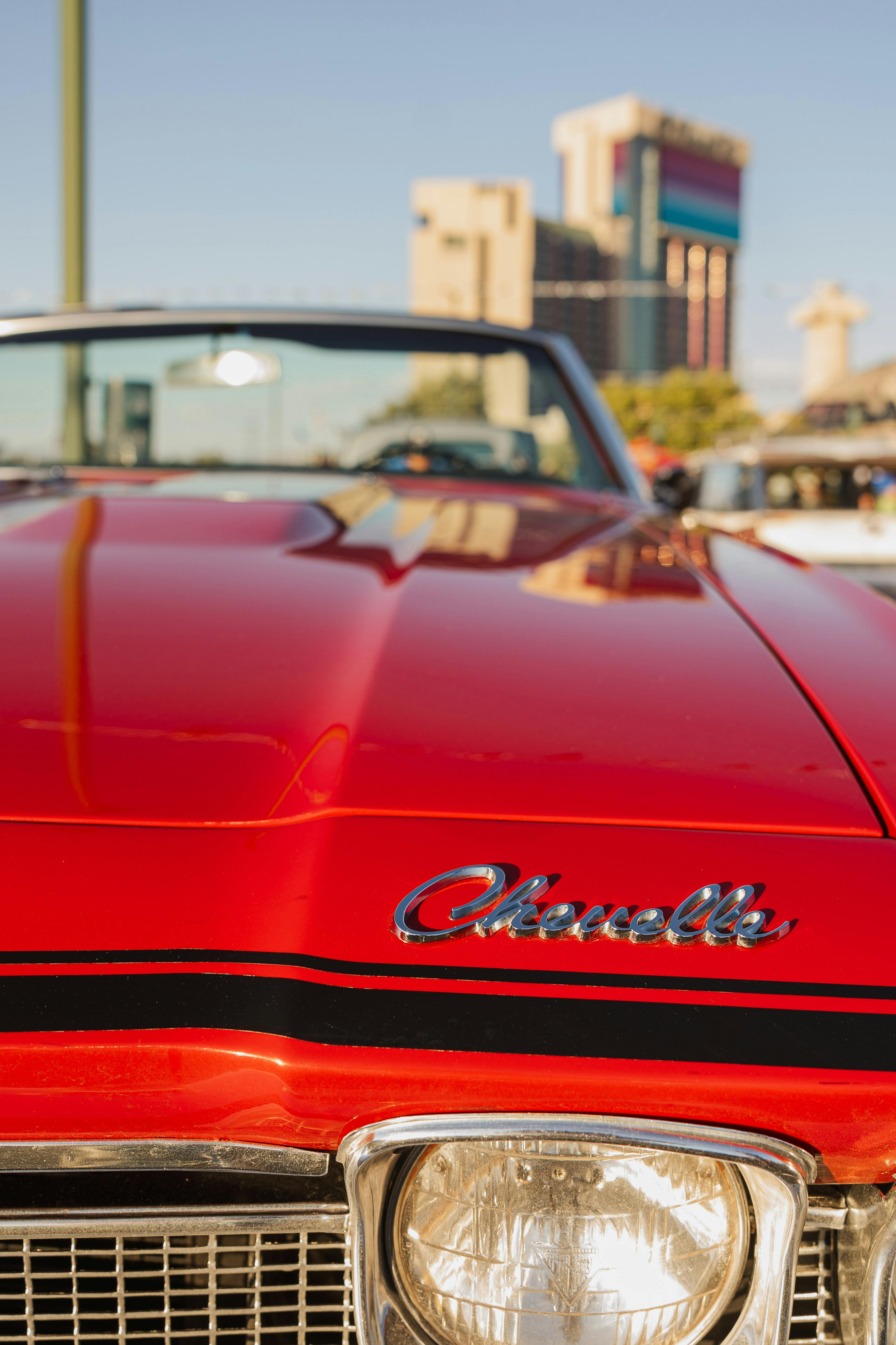 Vibrant red Chevelle convertible with cityscape background in Reno.