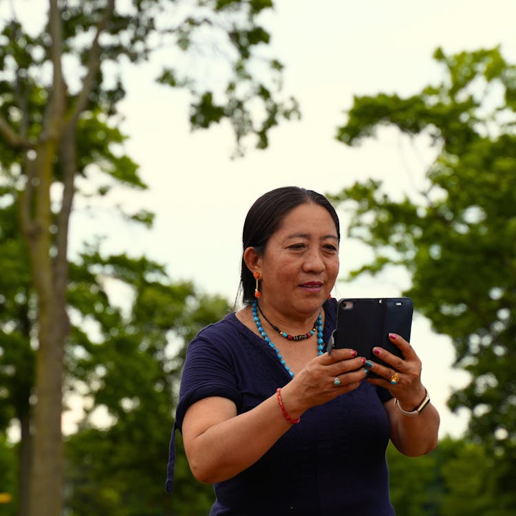 A Middle Aged Woman Looking At The Smartphone