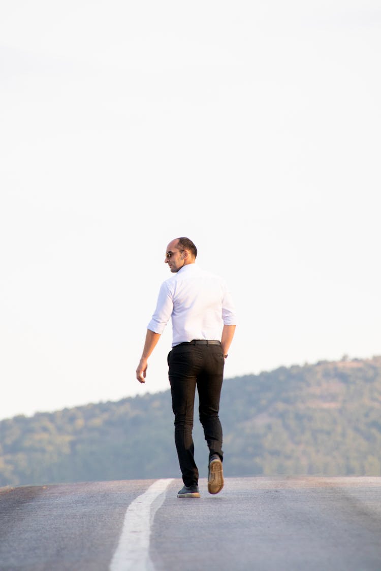 Man In White Shirt Walking On Road